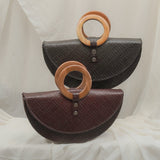 Two handbags with wooden rings on a white fabric background