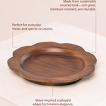 Wooden tray with scalloped edges on a white background, featuring text about sustainability and design.