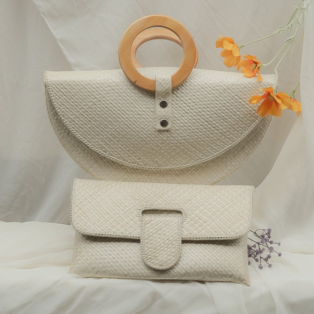 White woven bag with a wooden ring and orange flower on a white background