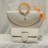 White woven bag with a wooden ring and orange flower on a white background