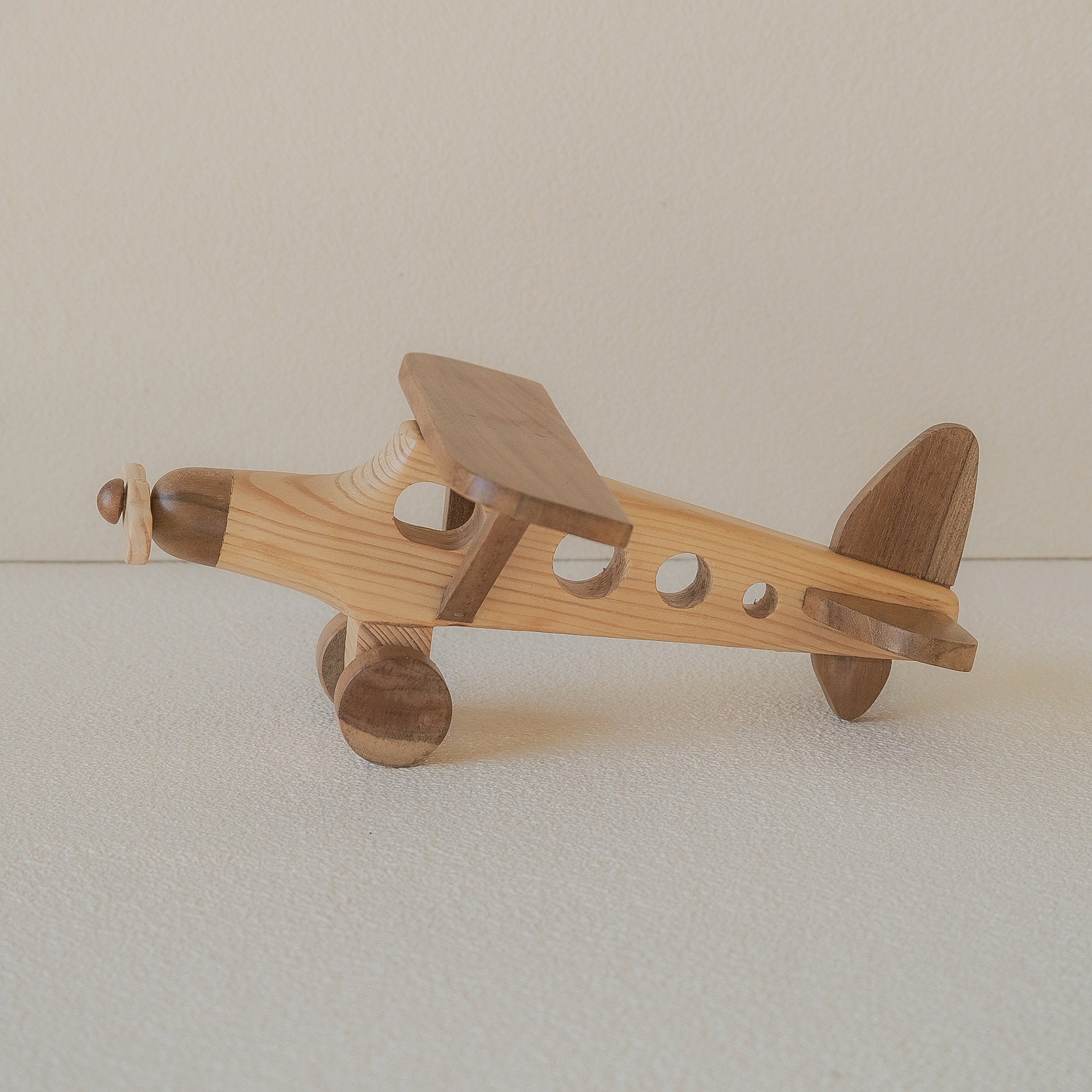 Wooden airplane toy on a plain background