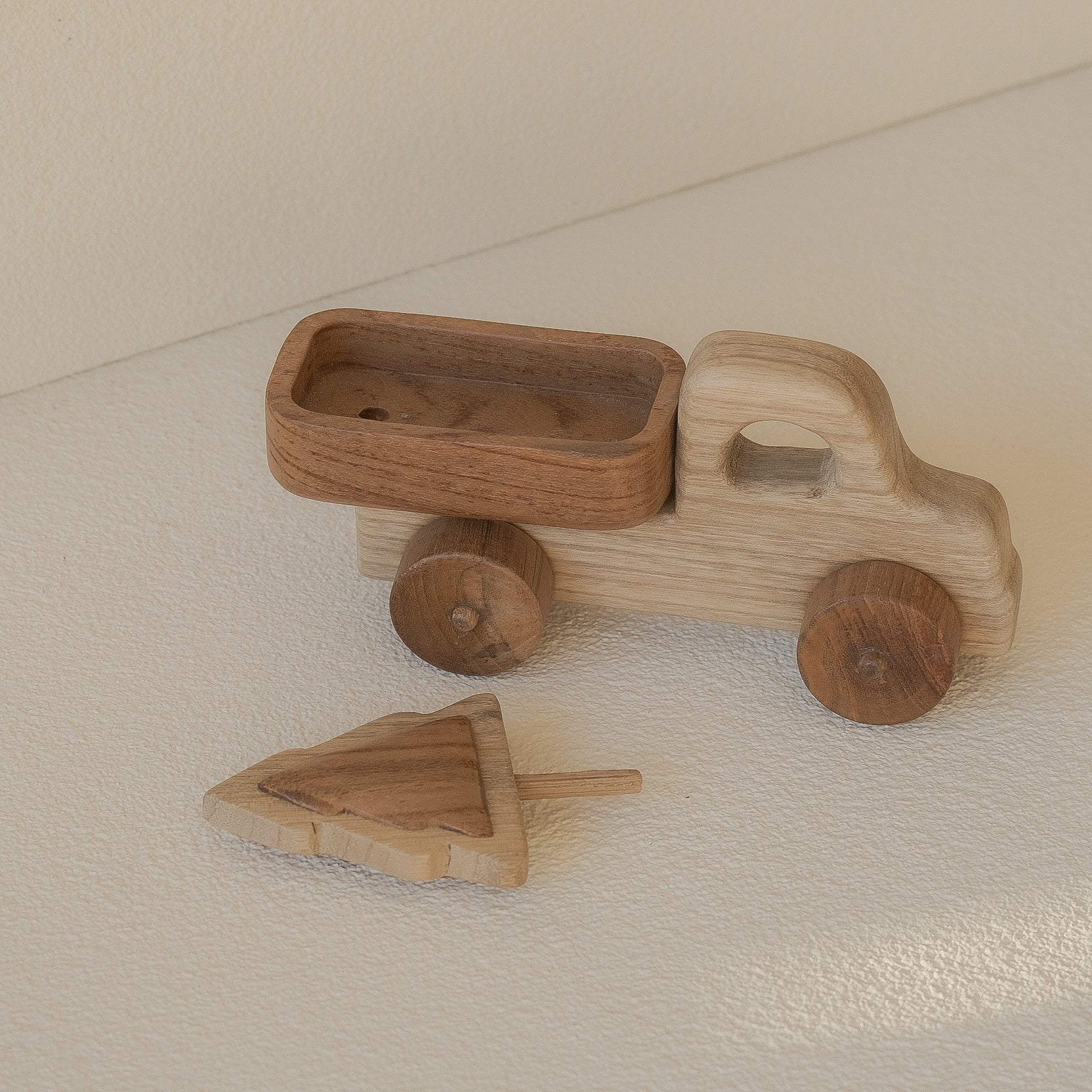 Wooden toy truck and arrow on a beige surface