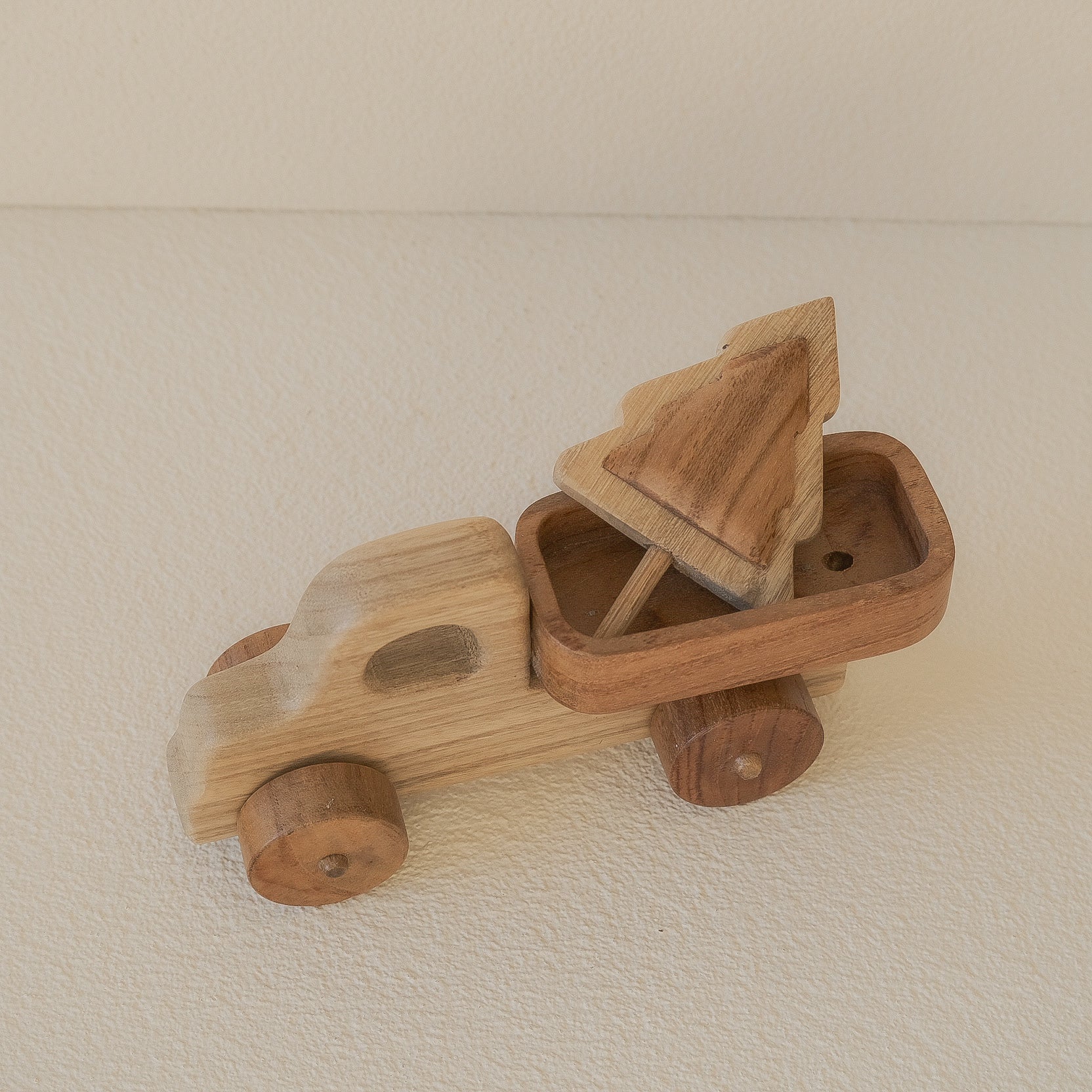 Wooden toy car with a driver figure on a beige surface