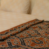 Amber Dusk Handloom Blanket – A fully handwoven cotton throw in rich amber and black hues, crafted using traditional handloom techniques.