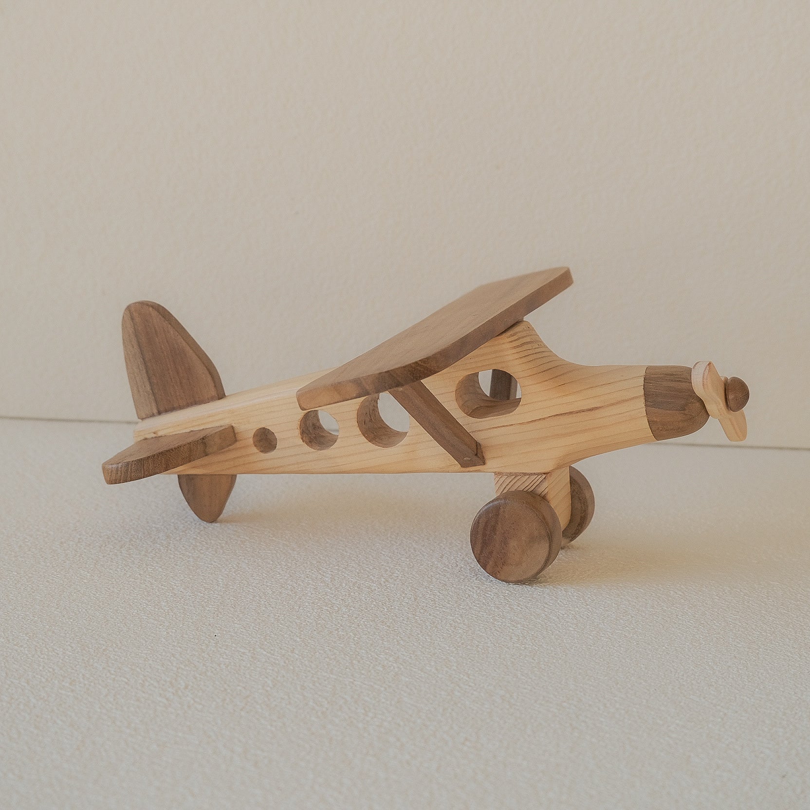 Wooden toy airplane on a plain background