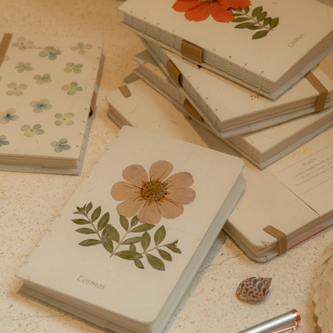 A6 cosmos flower journal with real pressed bloom on the cover, floral pen, and dust bag – colours may vary