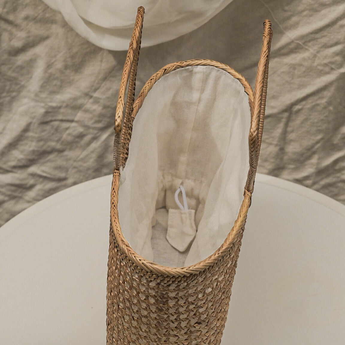Woven basket with a white interior on a neutral background