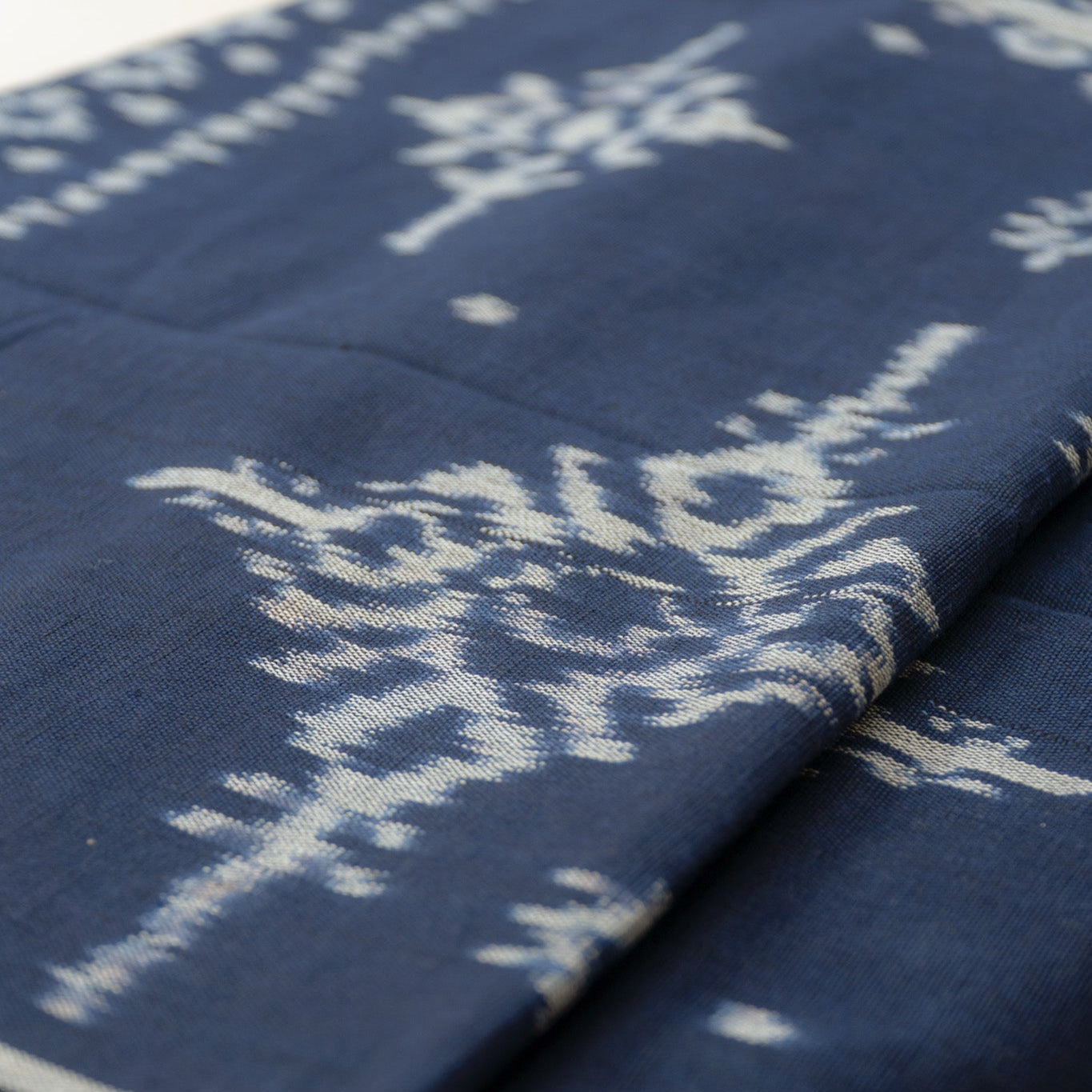 Indigo Eclipse Handloom Blanket, handwoven from 100% natural cotton with intricate patterns in deep indigo hues, crafted using traditional techniques.