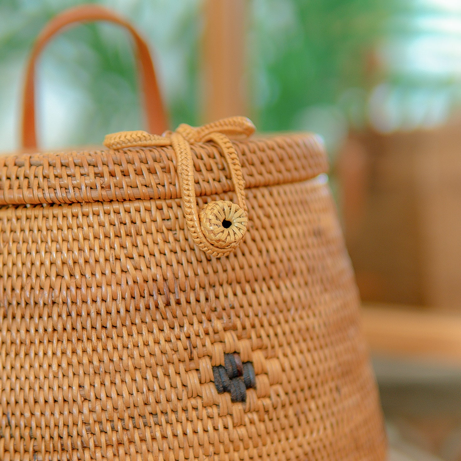 Close-up of Pipa backpack with a decorative knot and button on a blurred background