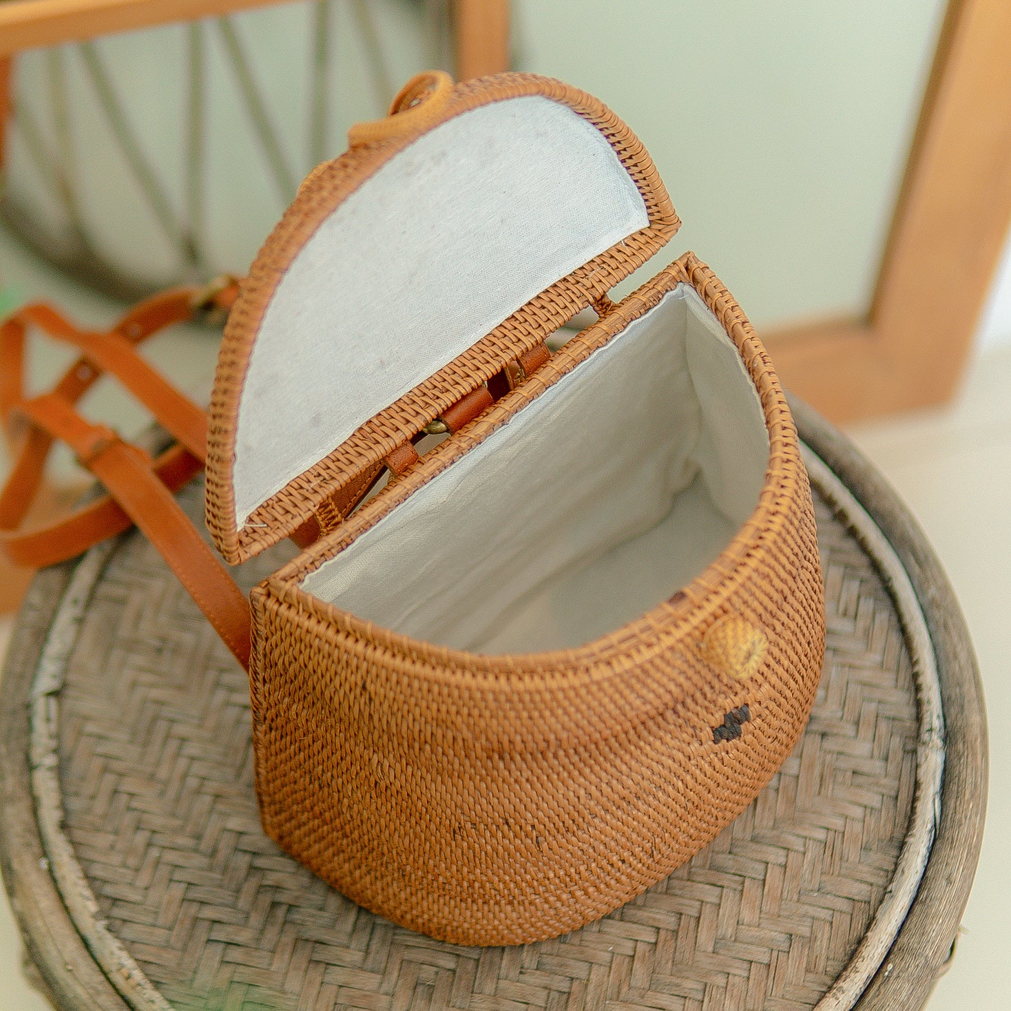 Pipa woven handbag with a white interior on a textured surface