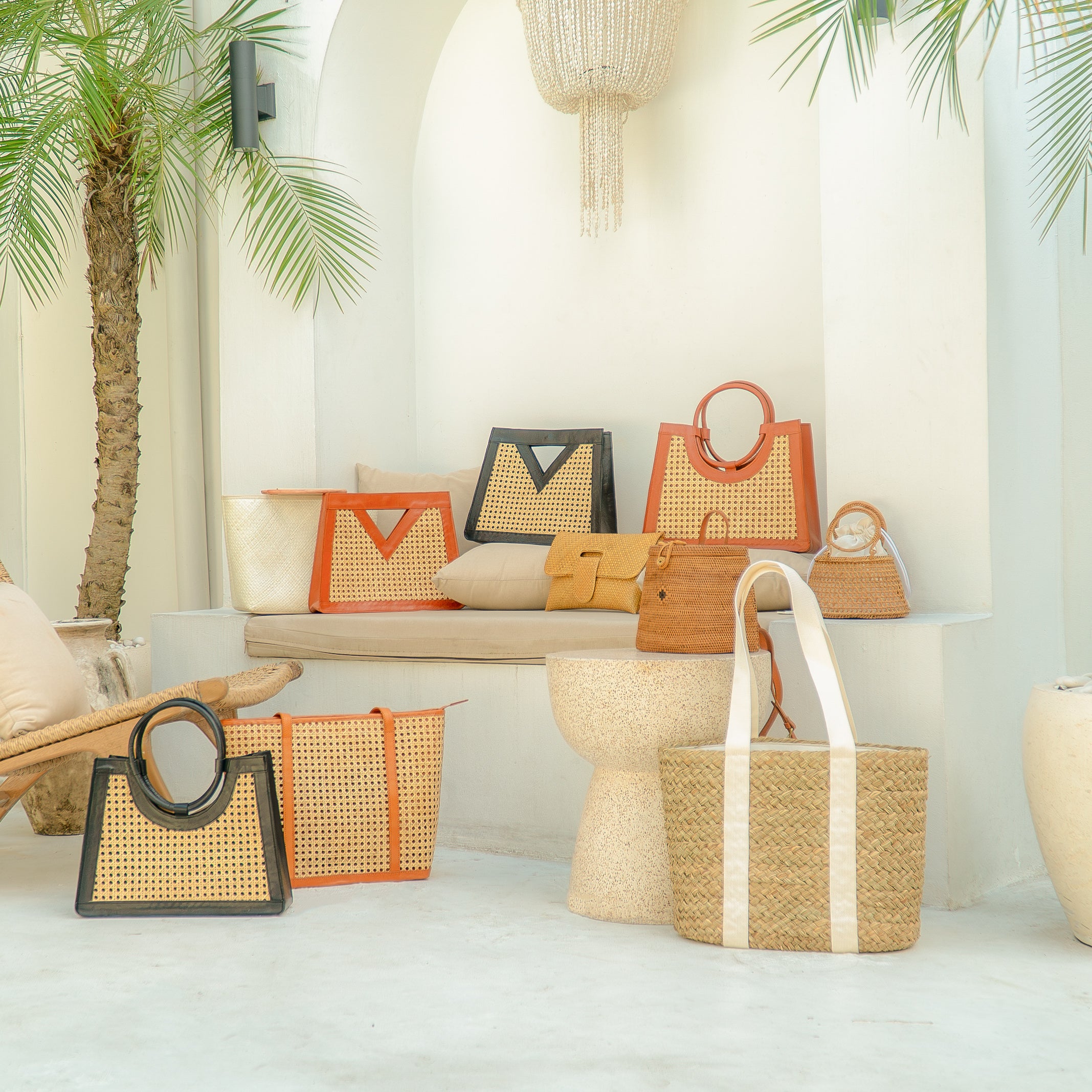 Collection of woven handbags and baskets on a white surface with a neutral background