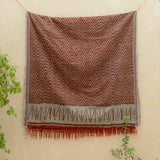 Terracotta Dawn Handloom Blanket – A fully handwoven cotton throw with intricate terracotta and ivory patterns, crafted using traditional artisan techniques.