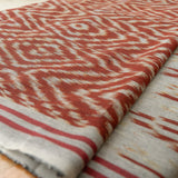 Terracotta Dawn Handloom Blanket – A fully handwoven cotton throw with intricate terracotta and ivory patterns, crafted using traditional artisan techniques.