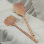 Two wooden spoons on a white fabric background