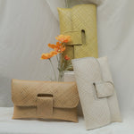 yellow, white and cream handbags on a white surface with draped fabric in the background