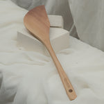 Wooden scrapper spatula on a white fabric background