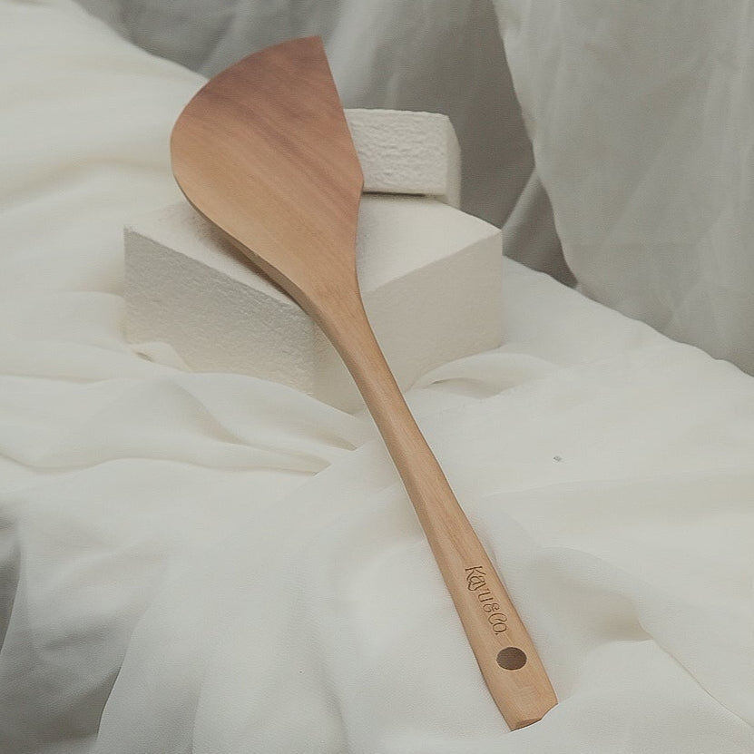 Wooden scrapper spatula on a white fabric background