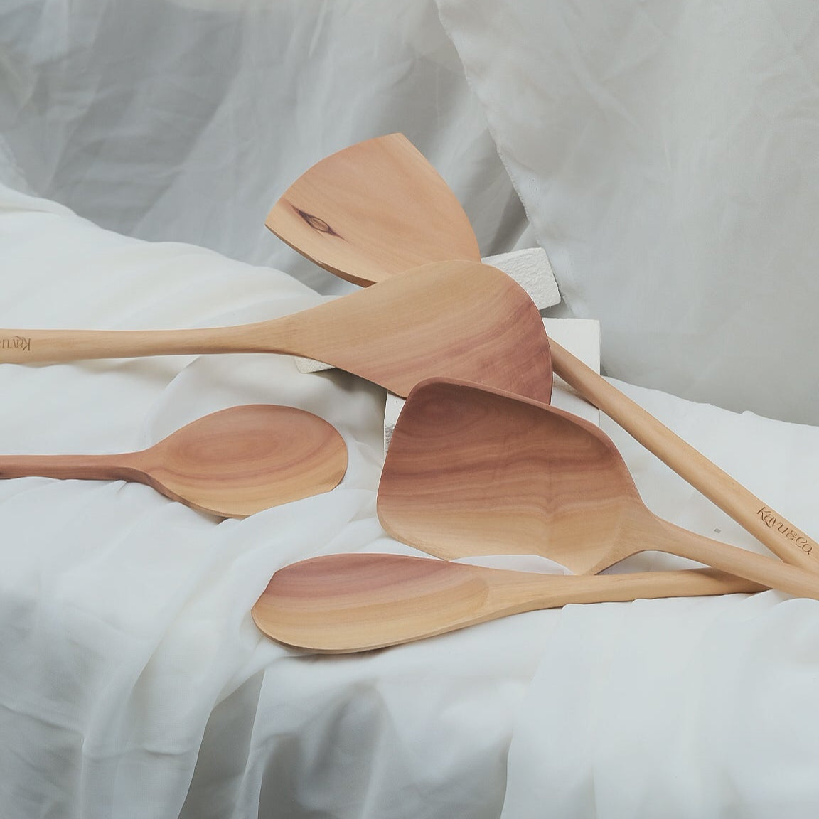Set of wooden spoons on a white fabric background