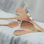 Set of wooden spoons on a white fabric background