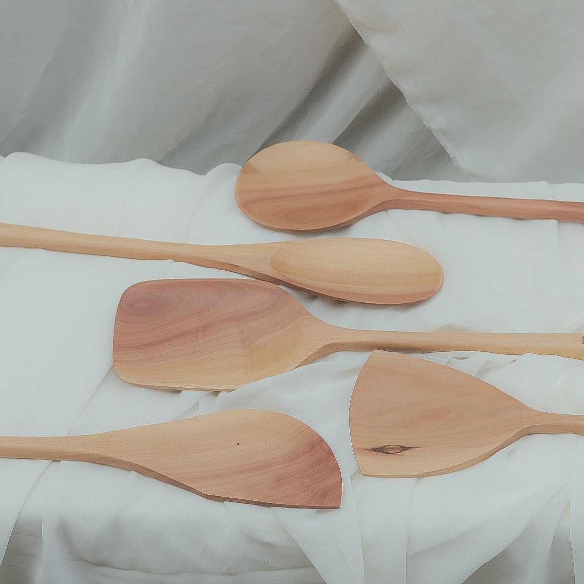 Set of wooden spoons on a white fabric background