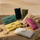 Colorful handbags on a sandy surface with a desert background