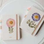 A6 journal with real pressed Aster flower on cover, floral pen, and dusty pouch