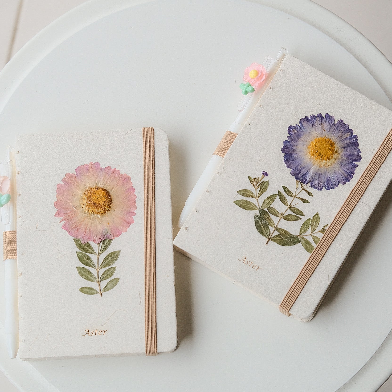 A6 journal with real pressed Aster flower on cover, floral pen, and dusty pouch
