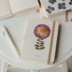 A6 journal with real pressed Aster flower on cover, floral pen, and dusty pouch