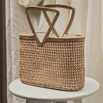 Woven straw bag on a white stool with a neutral background