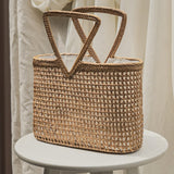Woven straw bag on a white stool with a neutral background