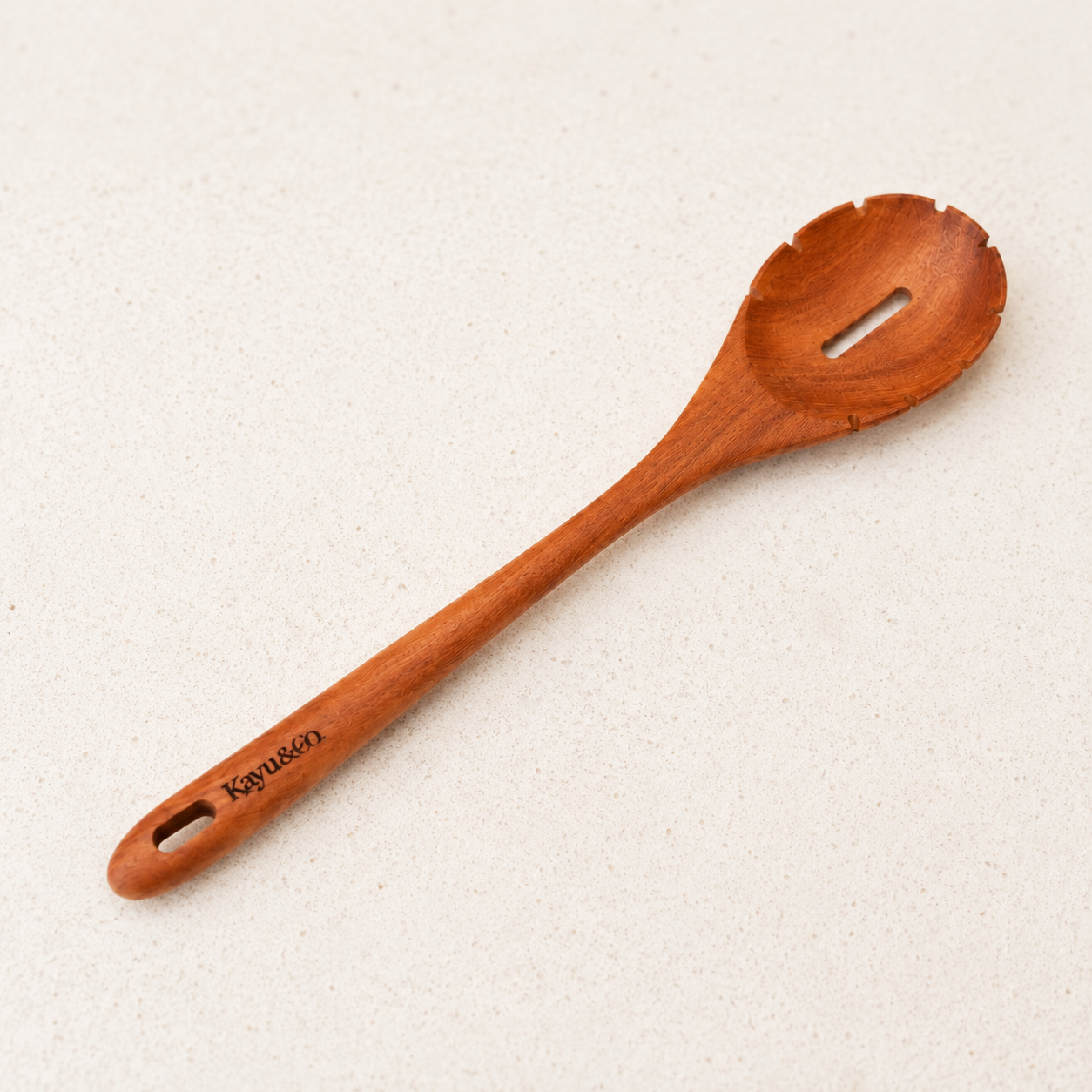 Wooden spoon with 'Kavu' branding on a beige background