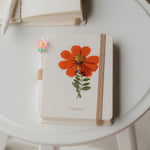 A6 cosmos flower journal with real pressed bloom on the cover, floral pen, and dust bag – colors may vary