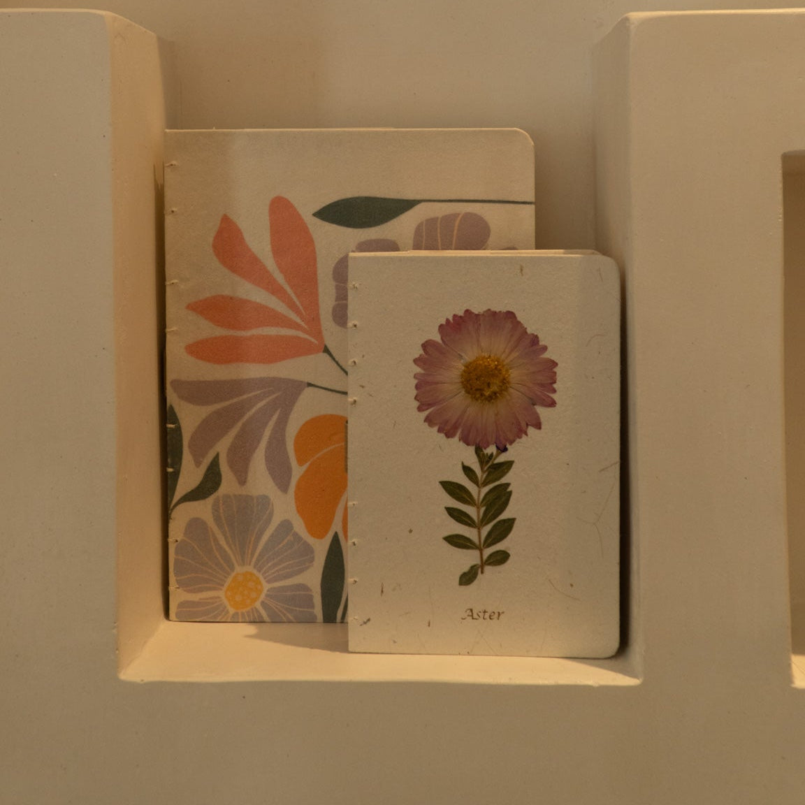 Sustainable hand-stitched notebook with vibrant floral market-inspired cover, made from upcycled newspapers, banana trunks, and dried leaves. Perfect for journaling and planning.