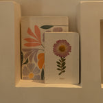 Sustainable hand-stitched notebook with vibrant floral market-inspired cover, made from upcycled newspapers, banana trunks, and dried leaves. Perfect for journaling and planning.