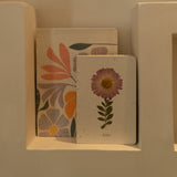 Sustainable hand-stitched notebook with vibrant floral market-inspired cover, made from upcycled newspapers, banana trunks, and dried leaves. Perfect for journaling and planning.