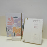 Sustainable hand-stitched notebook with vibrant floral market-inspired cover, made from upcycled newspapers, banana trunks, and dried leaves. Perfect for journaling and planning.