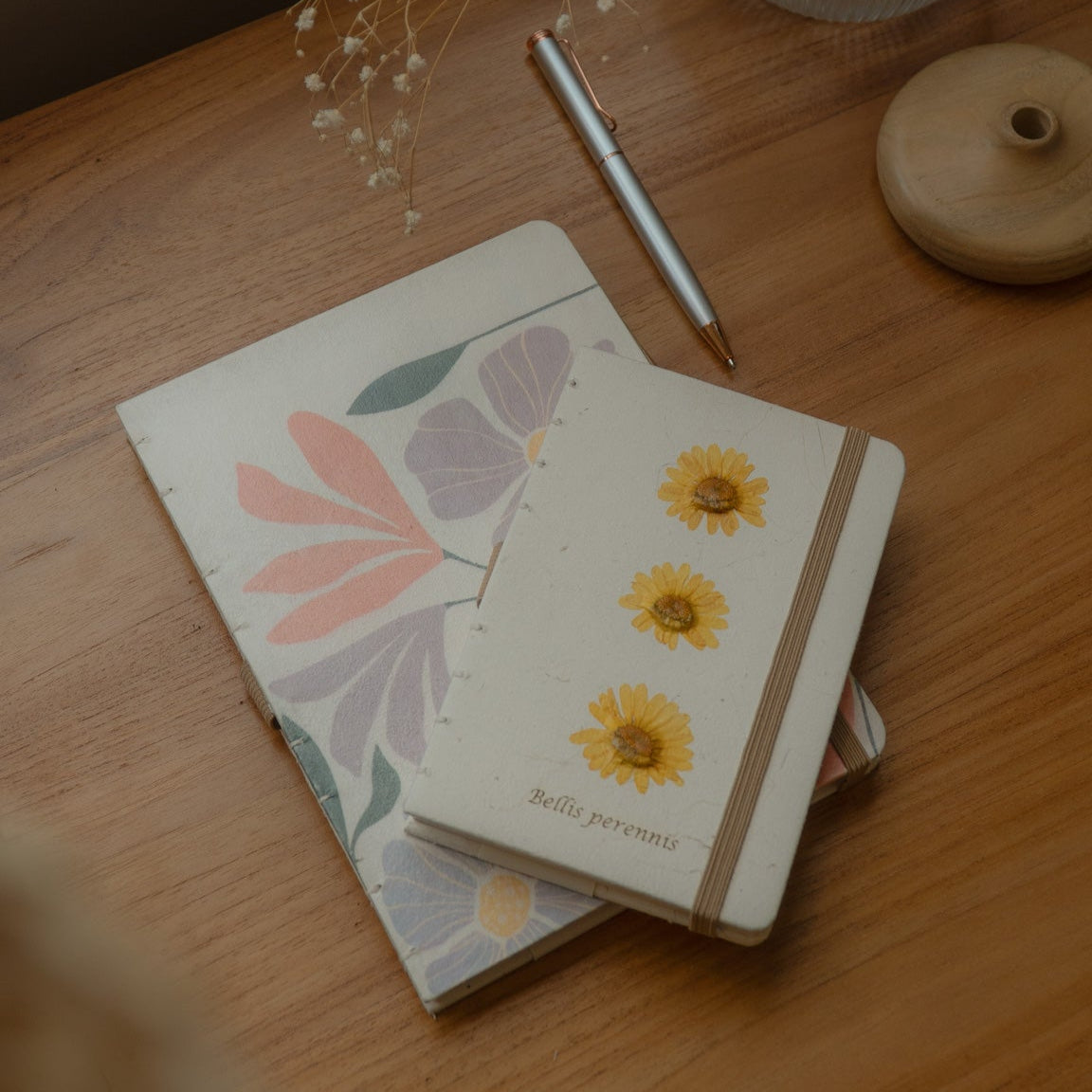 Sustainable hand-stitched notebook with vibrant floral market-inspired cover, made from upcycled newspapers, banana trunks, and dried leaves. Perfect for journaling and planning.