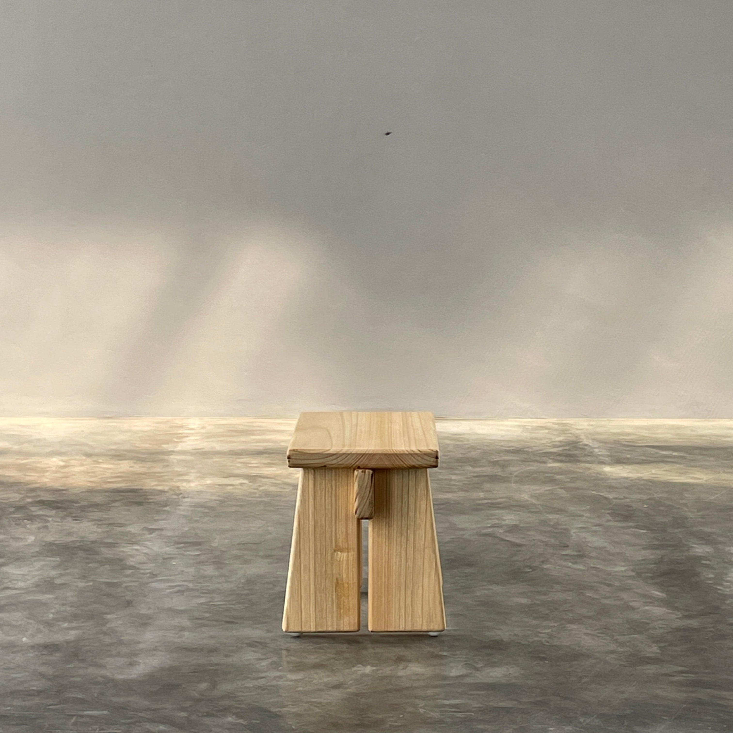 Wooden block on a gray surface with a light source casting shadows.