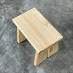 Wooden stool on a gray concrete surface