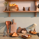 Kitchen counter with wooden shelves, utensils, and decorative items.