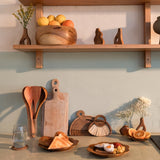 Kitchen counter with wooden shelves, utensils, and decorative items.
