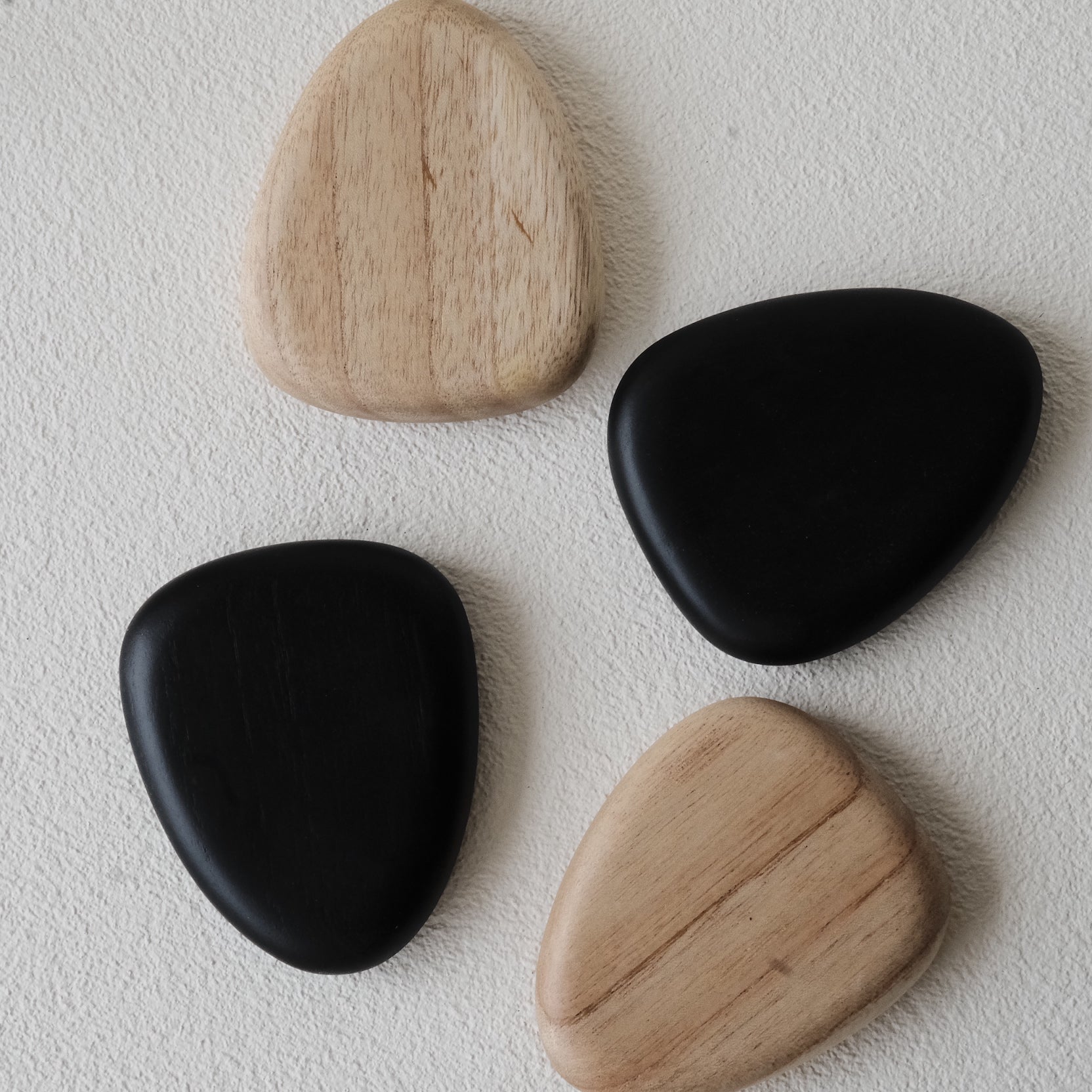 Set of 4 handcrafted Nami Wooden Pebble Coasters – available in Natural and Black Noir finish, wide smooth curved surface, eco-conscious Japandi style