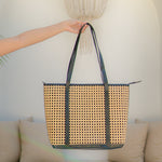 Sol tote bag with black straps held by a person against a neutral background
