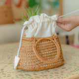 Camilla circle bag with a drawstring lid on a table, with a blurred background