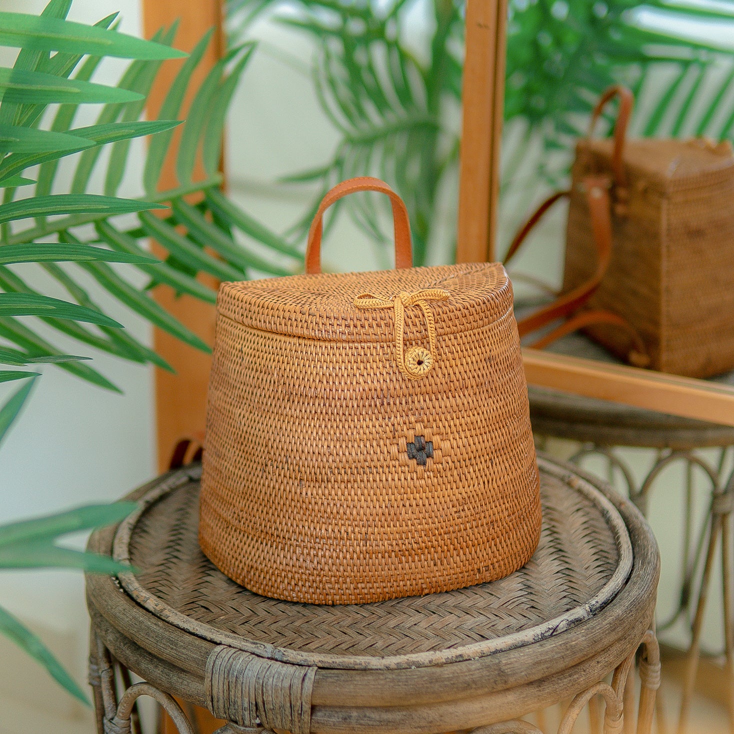 Pipa backpack with a decorative element on a wooden surface with plants in the background