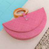 Pink Paloma clutch bag with wood handle by pool