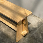 Wooden bench with a modern design on a gray concrete floor