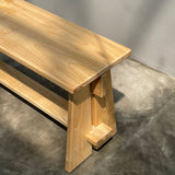 Wooden bench with a modern design on a gray concrete floor