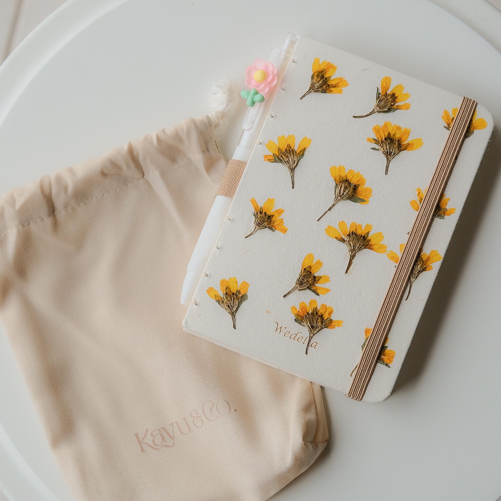A6 Wedelia flower journal made from real pressed petals and recycled paper. Includes floral pen and pouch. Naturally one-of-a-kind and eco-friendly.